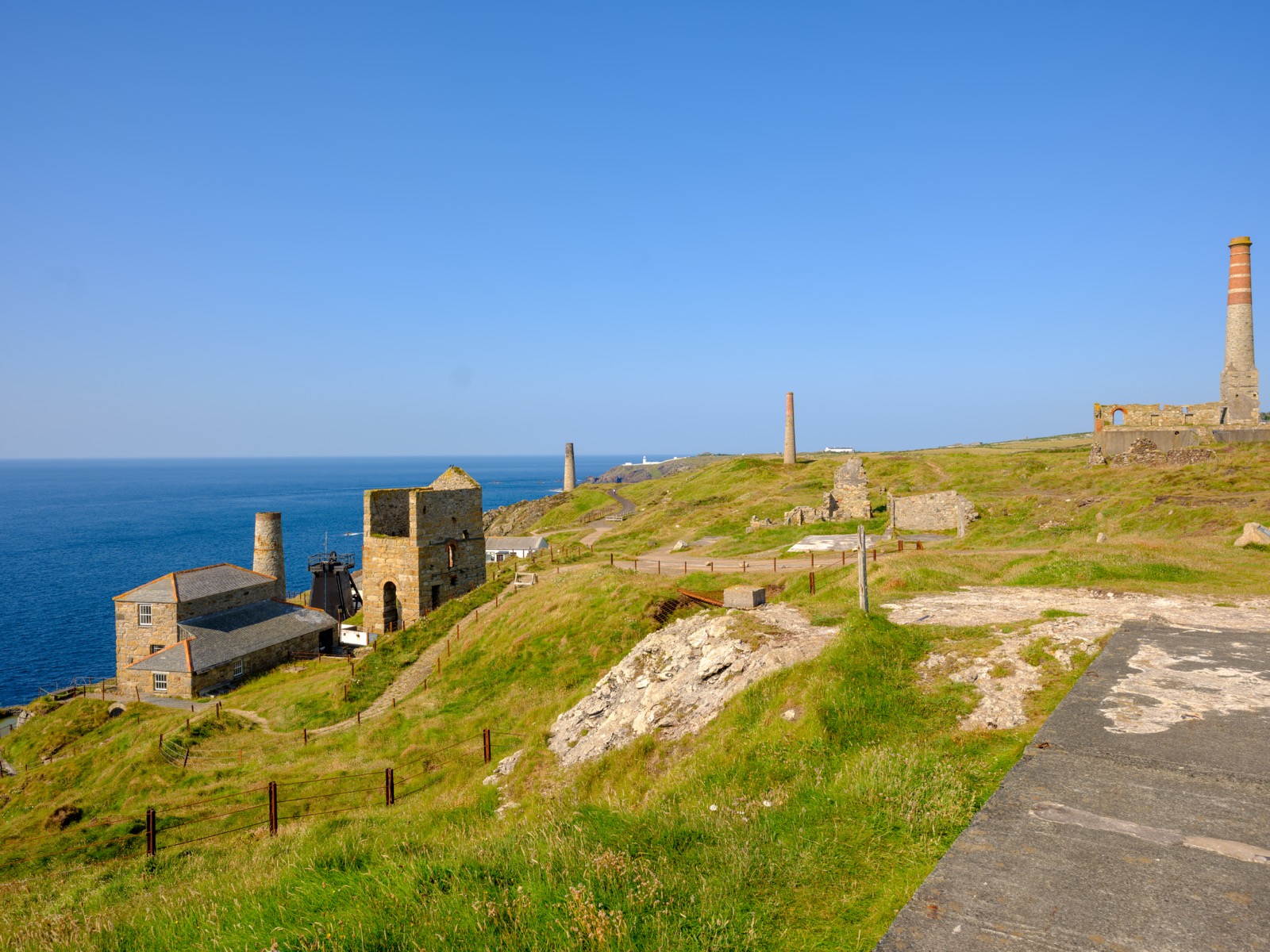 Engine houses and chimney stacks on the cliffs at Levant Mine above a blue sea