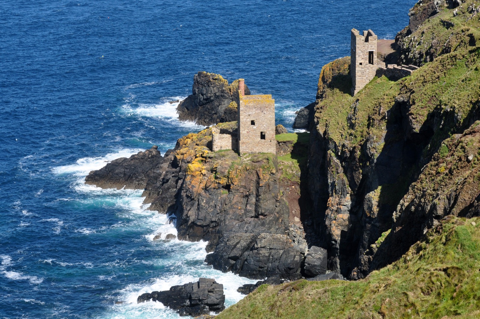 The Crowns engine houses on the cliffs at Botallack, west Cornwall, above a dark blue sea