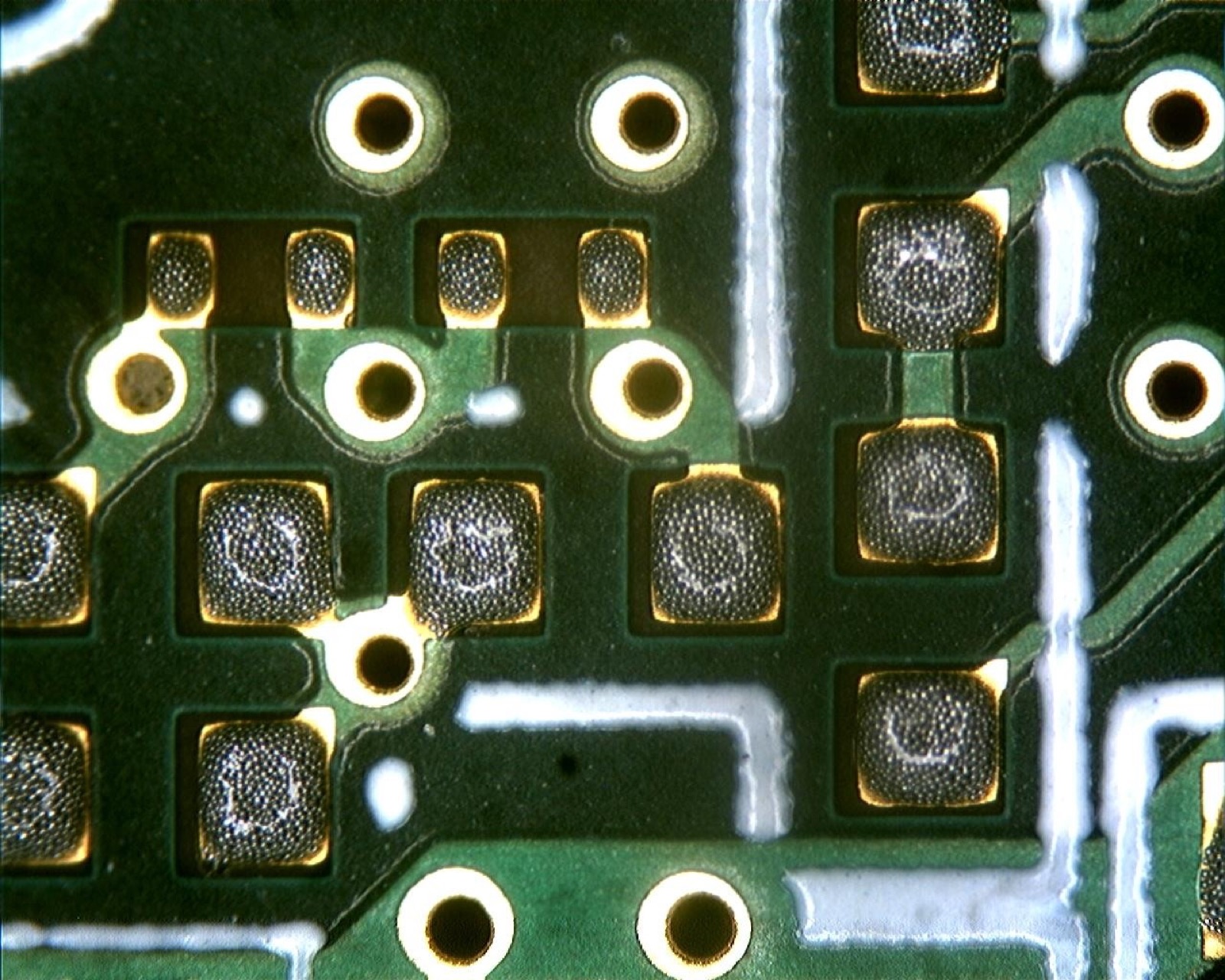 Grey solder paste printed in rectangular pads on a green printed circuit board